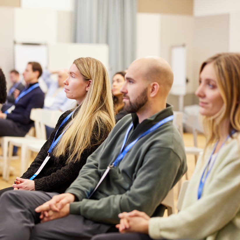 Group of people sitting at seminar and concentrated audience listening to speaker.