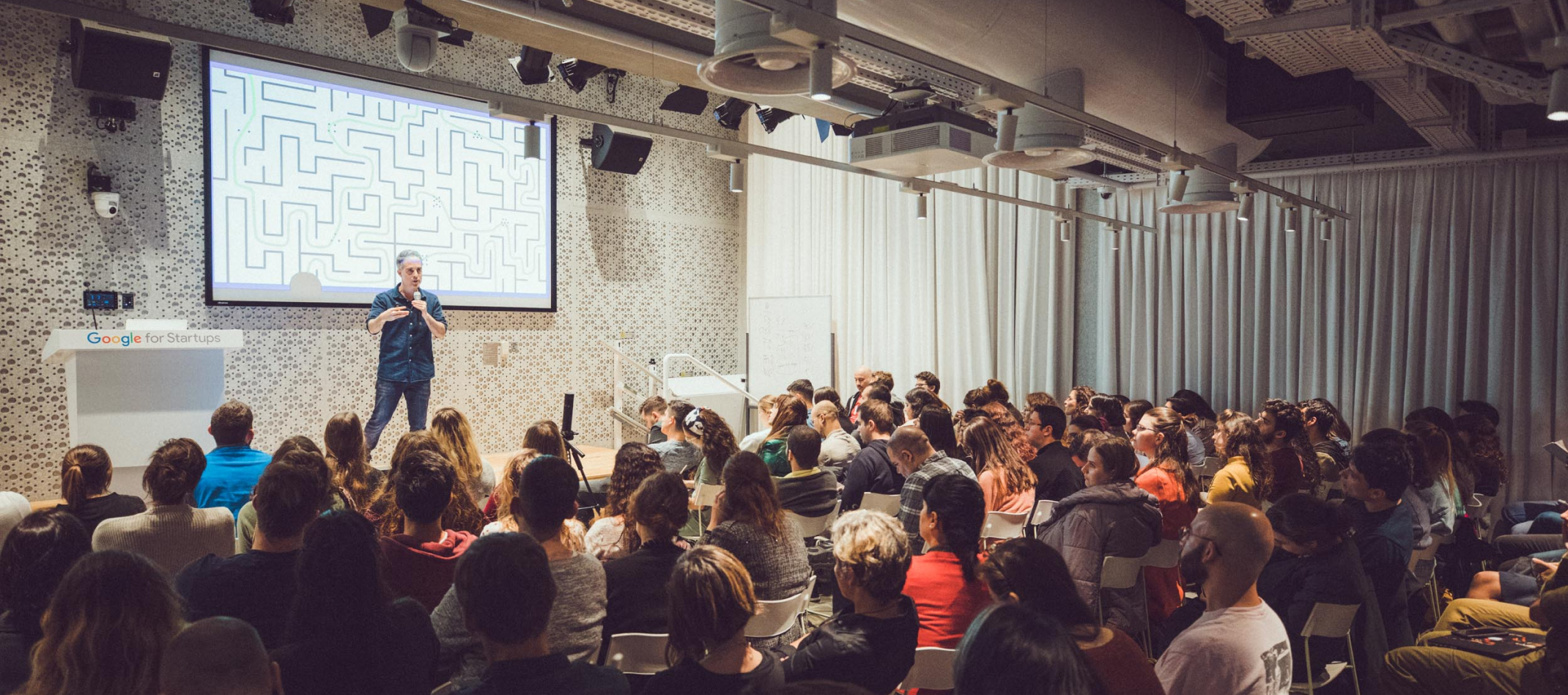 A man giving a presentation to a group of people in a conference room