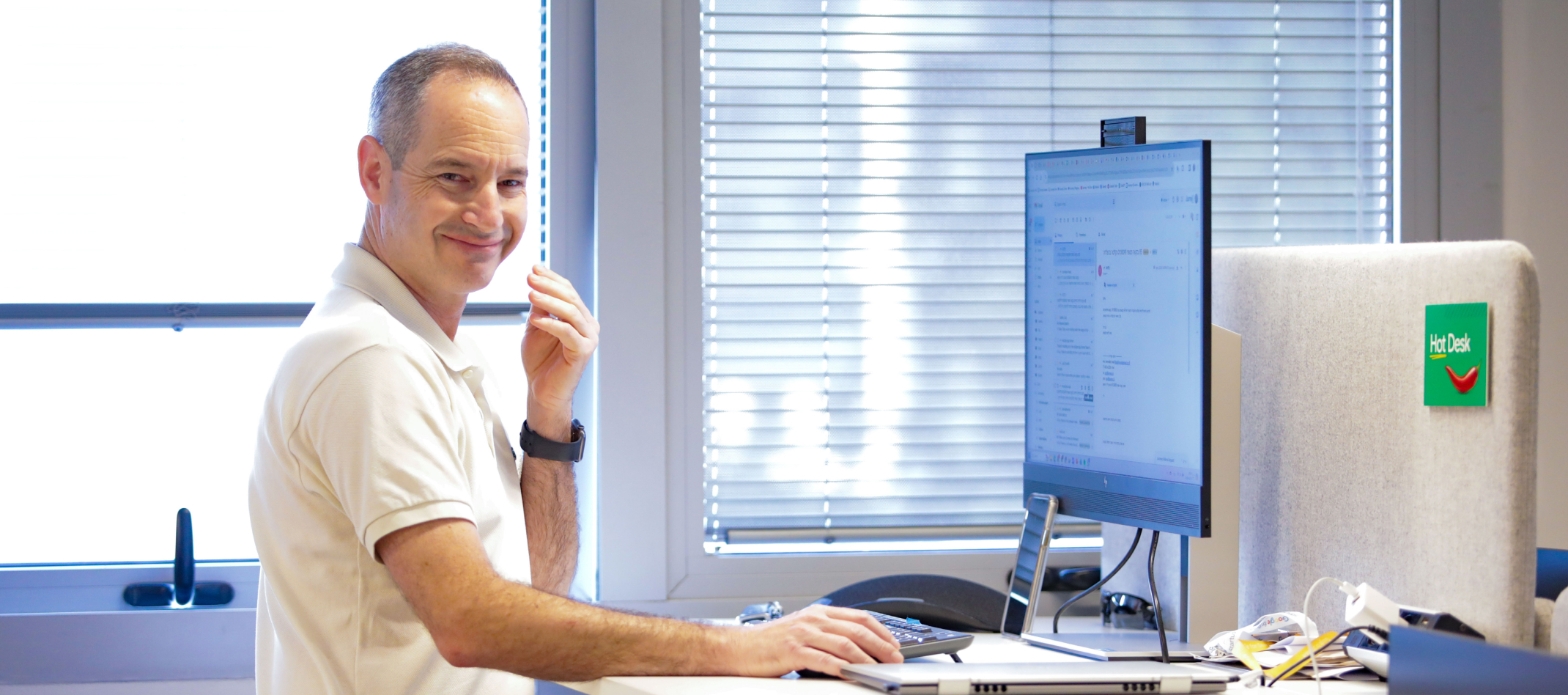 A man is smiling and working on laptop.