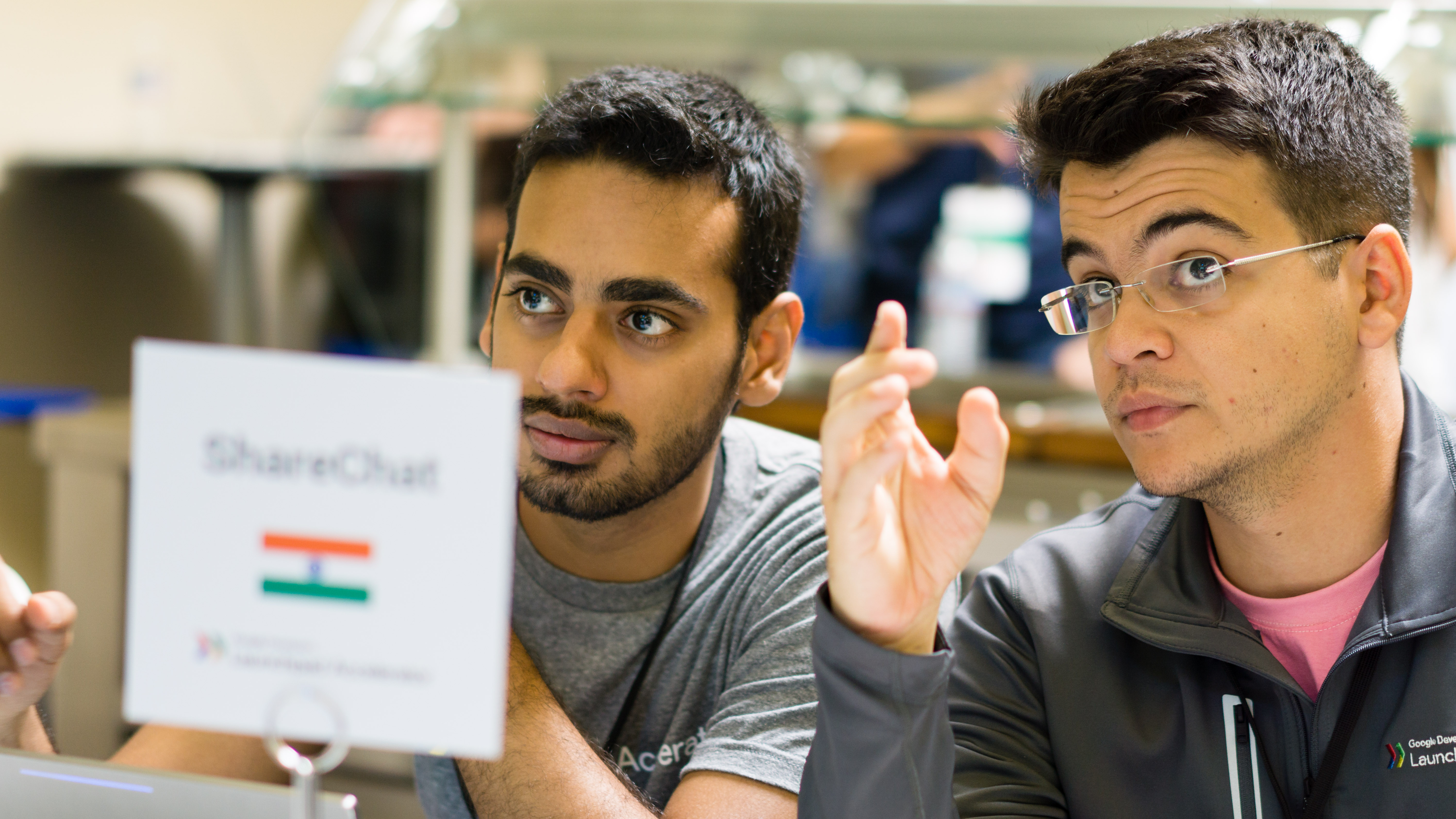 Two guys discussing something in front of laptop.