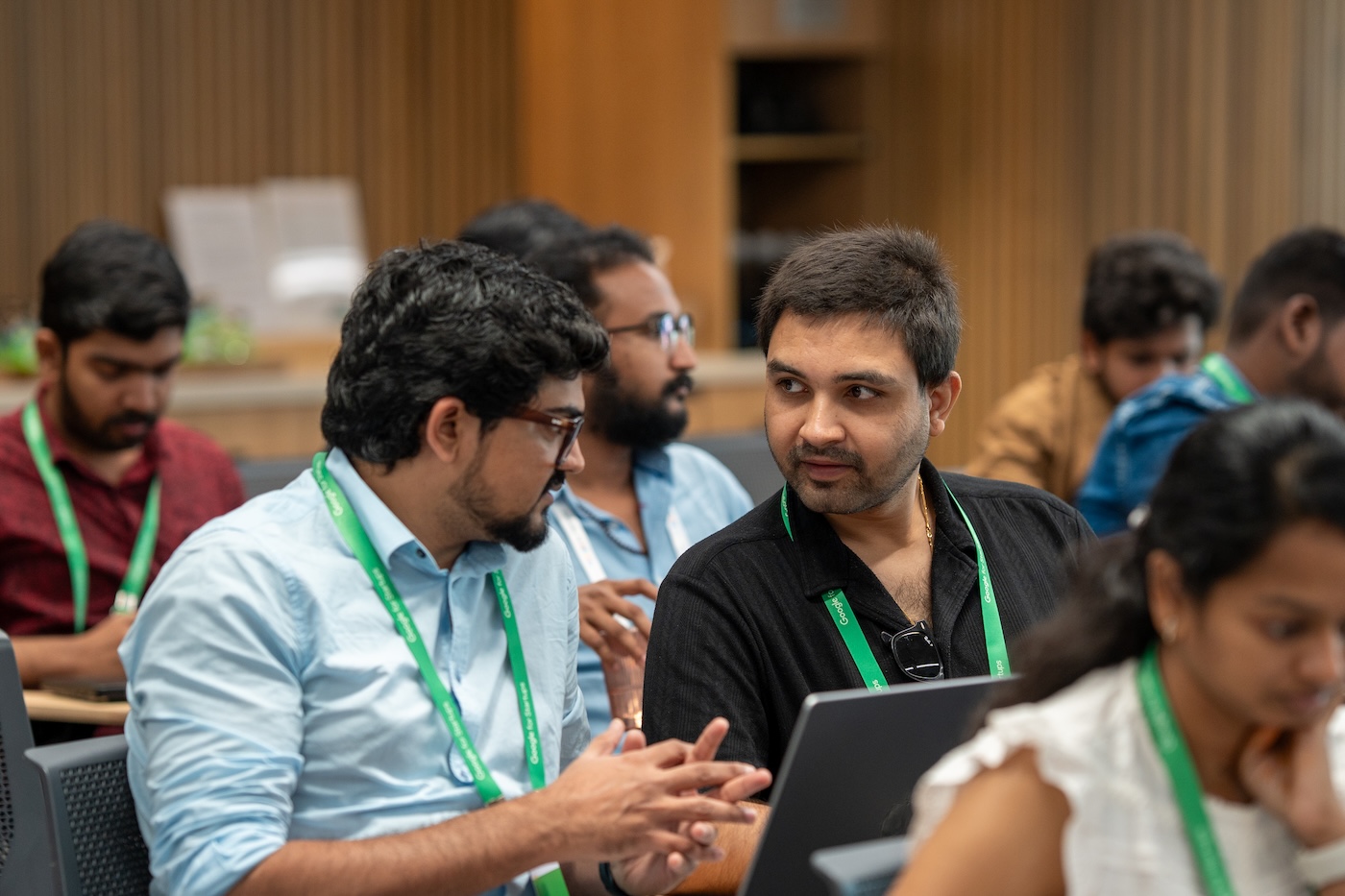 A man explaining something to other man who seated on his left.