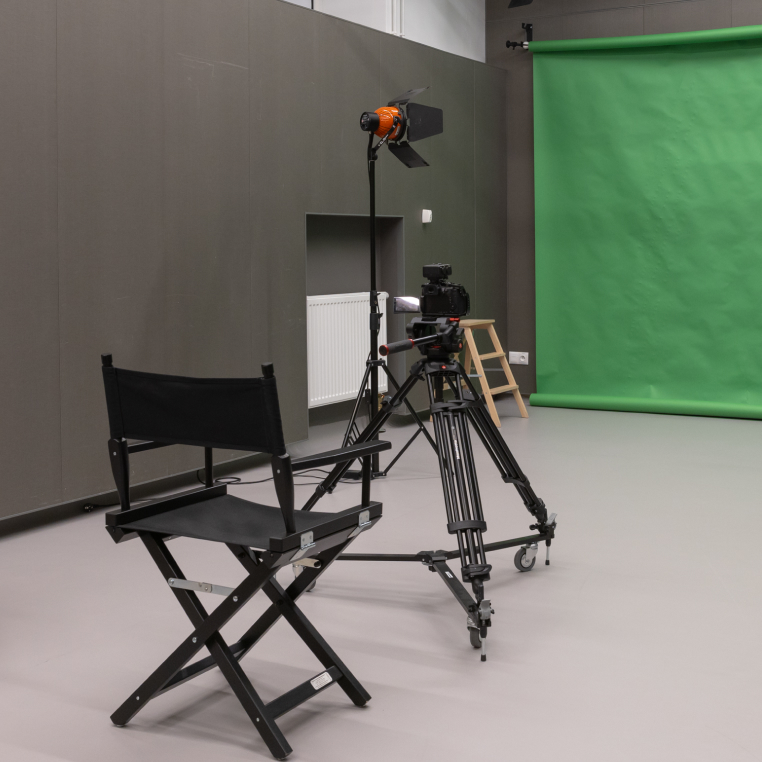 Studio for interview and podcast. One empty chair and spotlights in dark room.