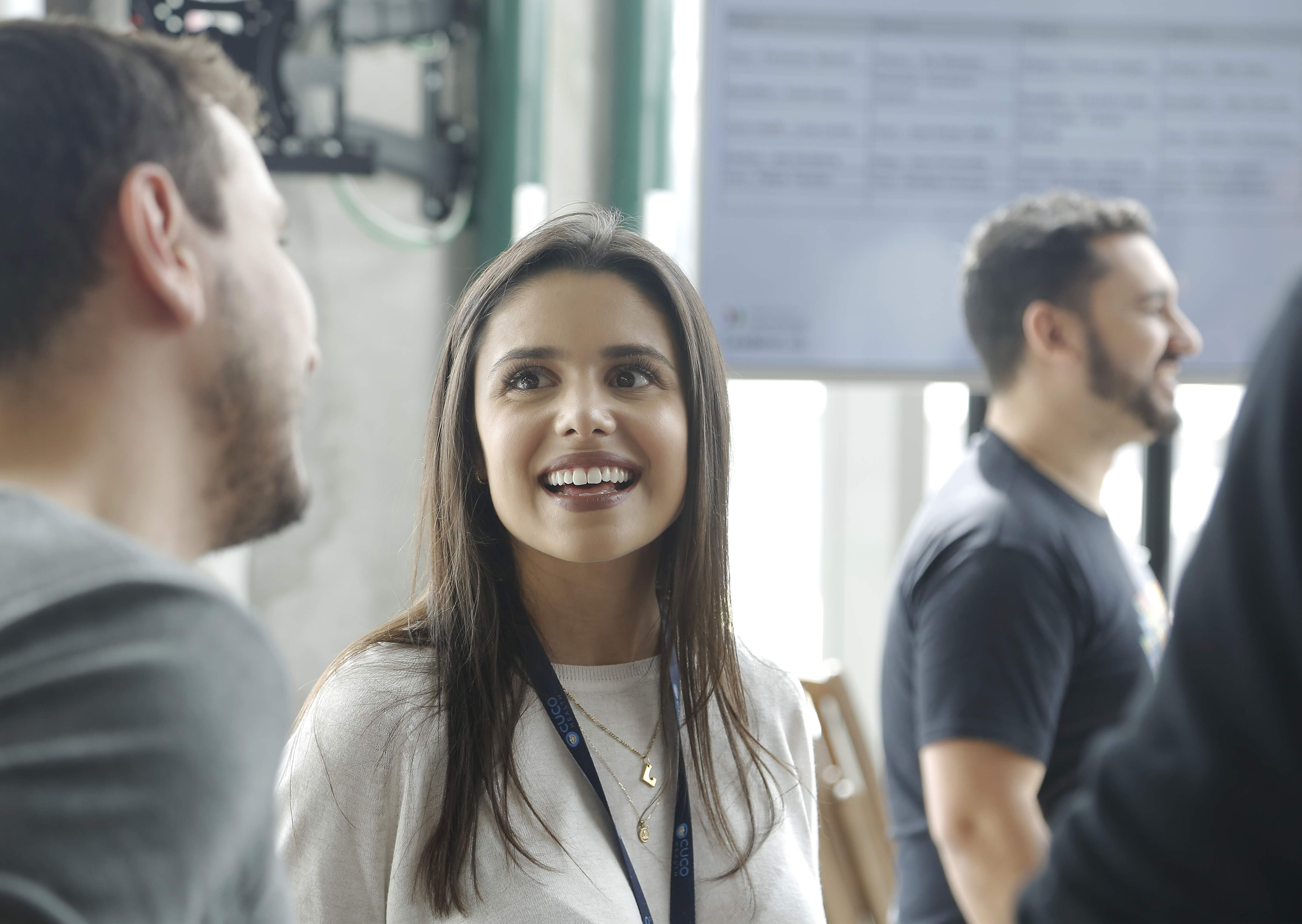 A woman is smiling while talking to a man.