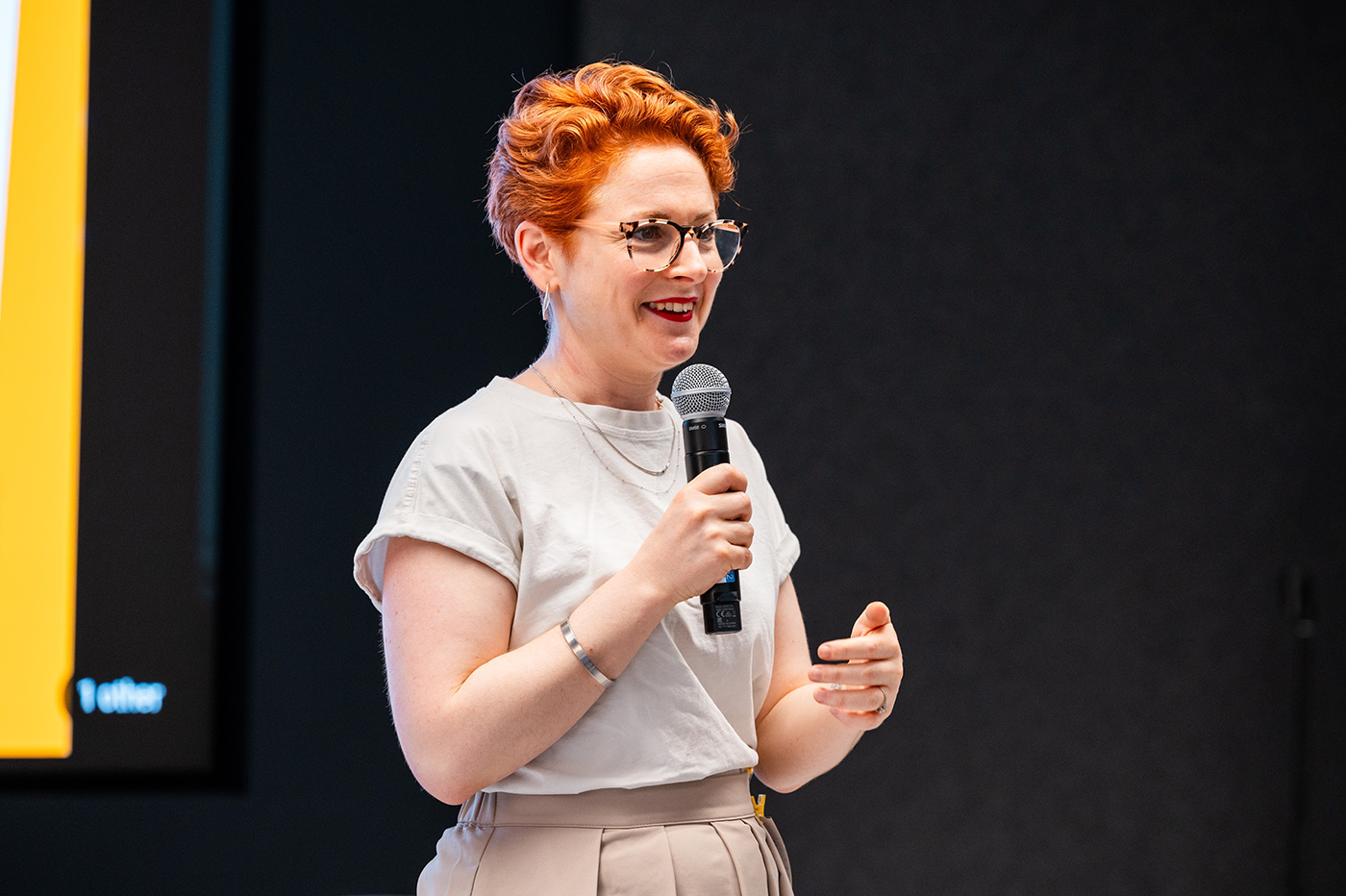 A female host, with a mic in hand, is delivering an excellent event.