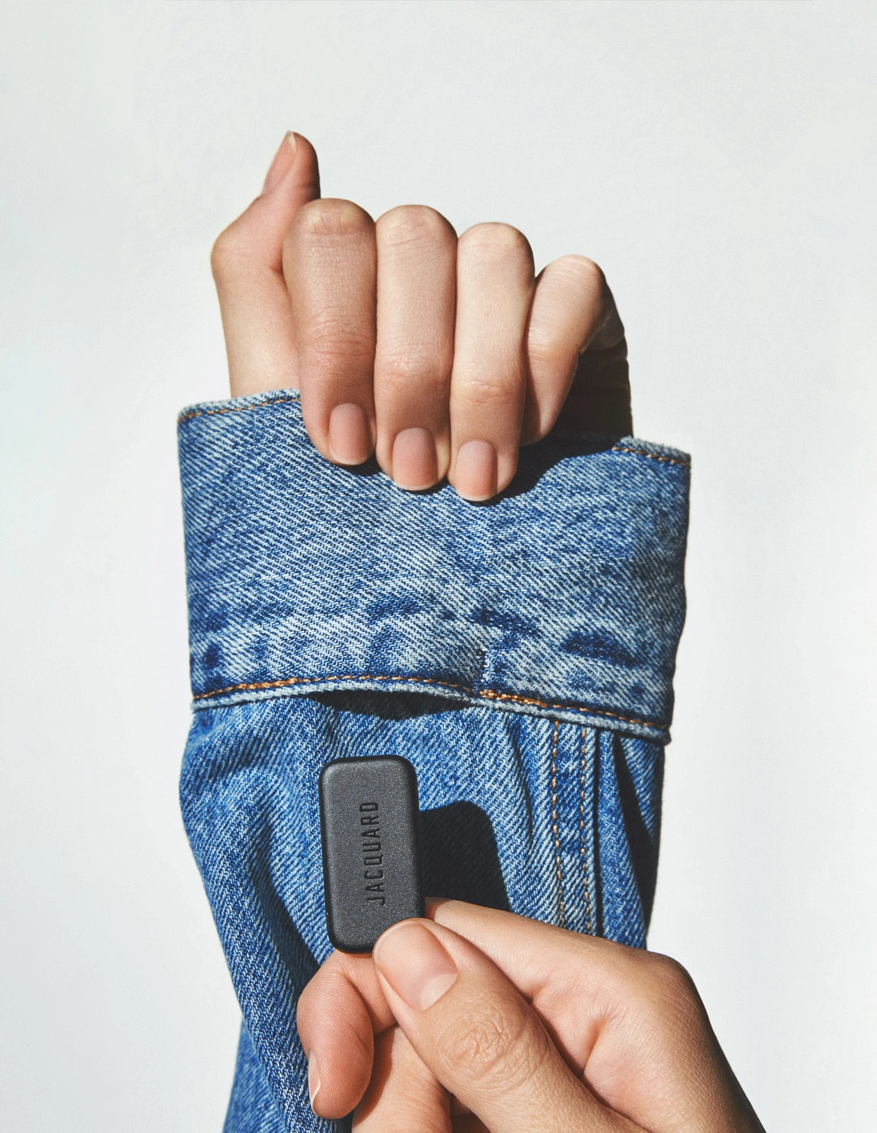 A Jacquard Tag being inserted into the sleeve of a Levi's Trucker jacket