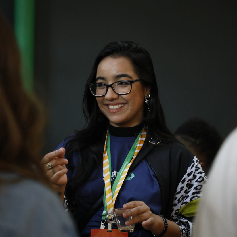 Portrait of young smiling lady in glasses standing and happily talking