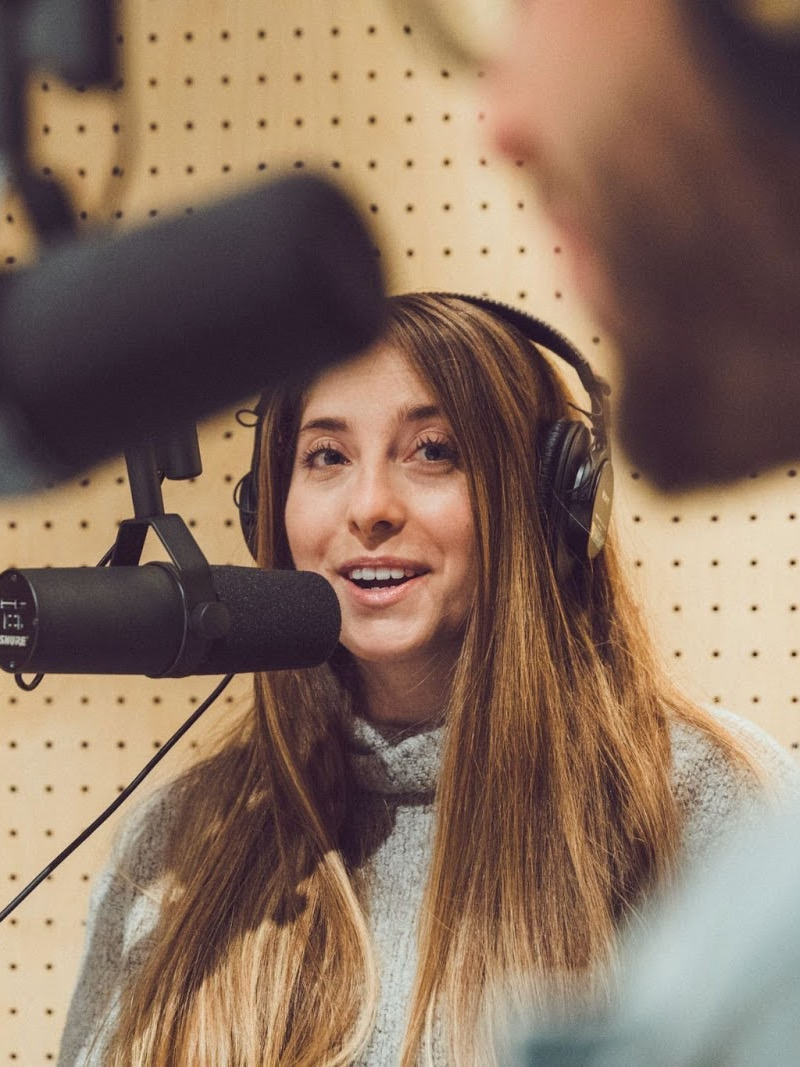 a woman talking on a microphone with her headphones on