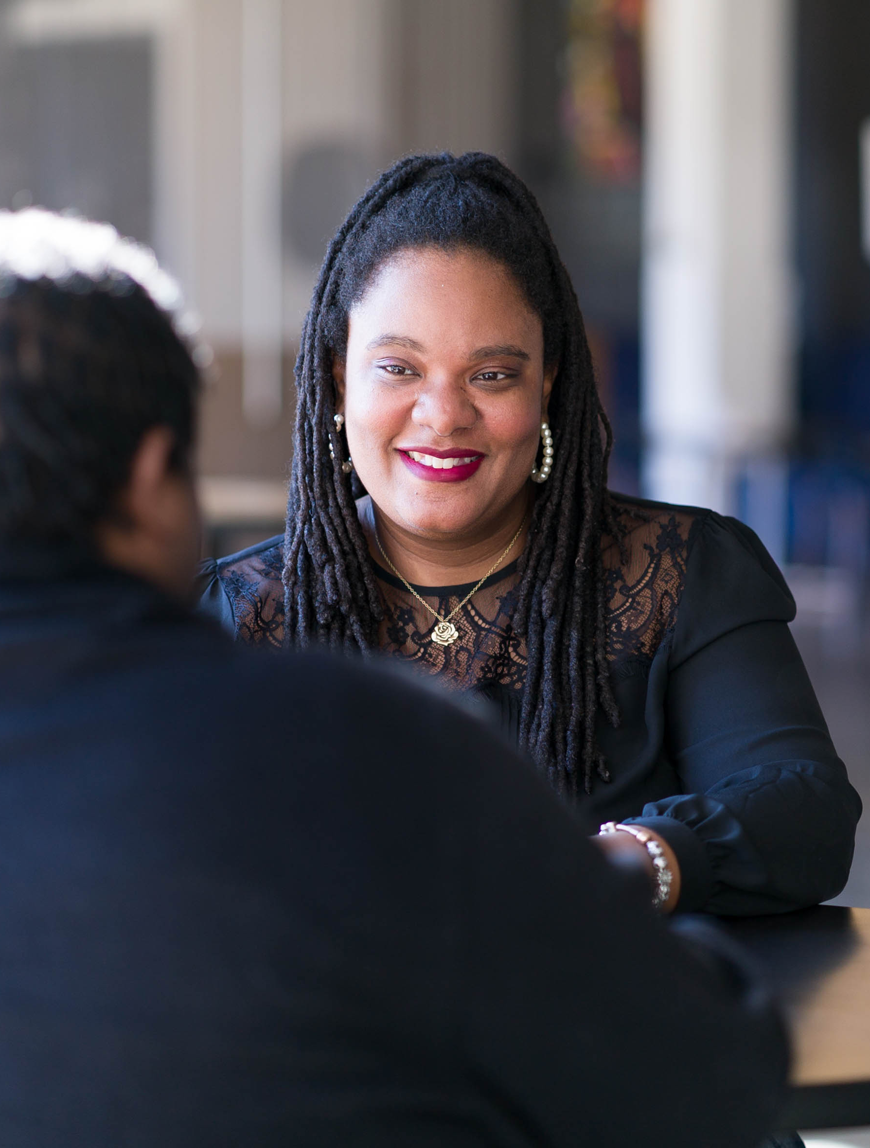 Woman chatting with a man, smiling.