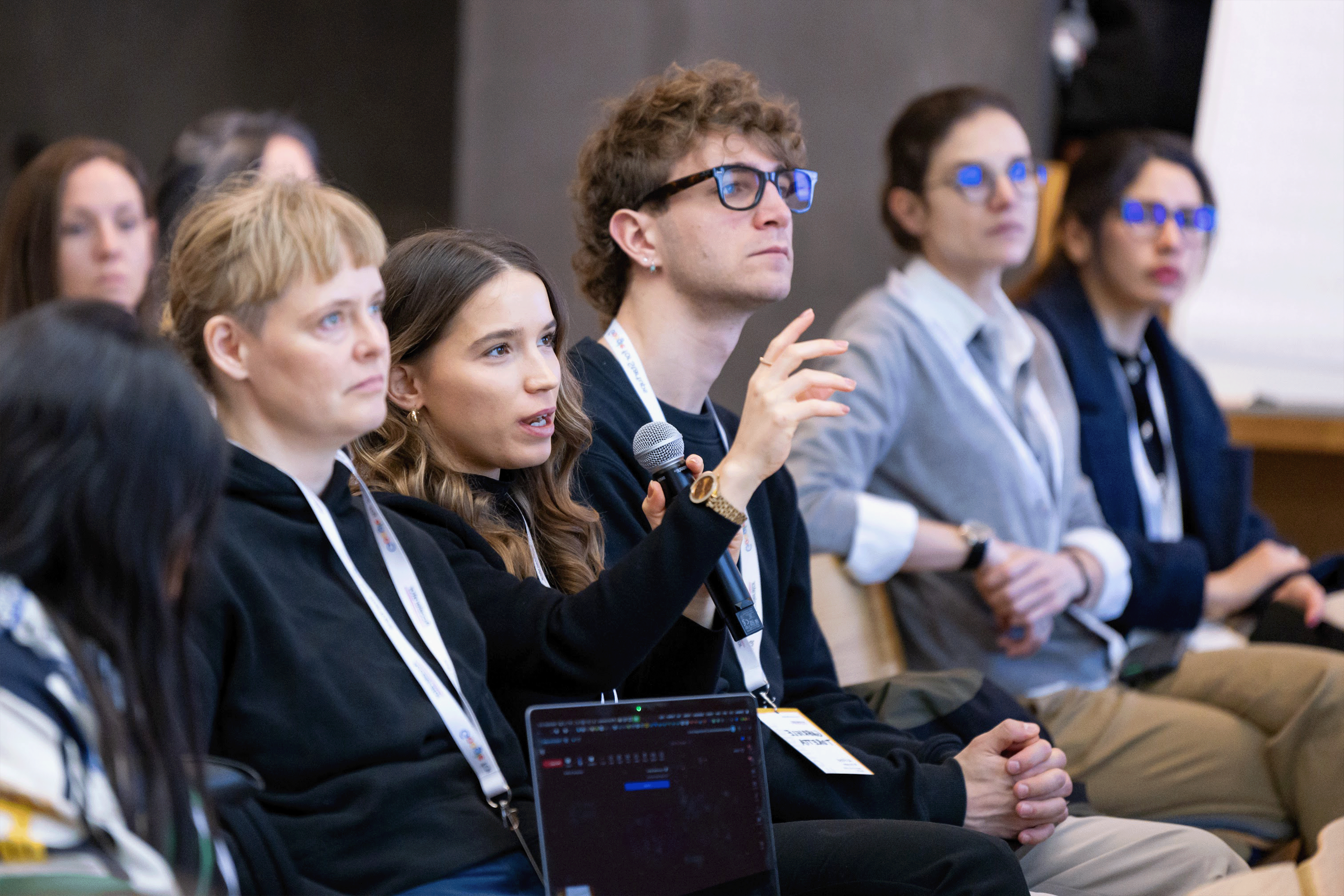 One woman in the audience is directing a question to the event's host.