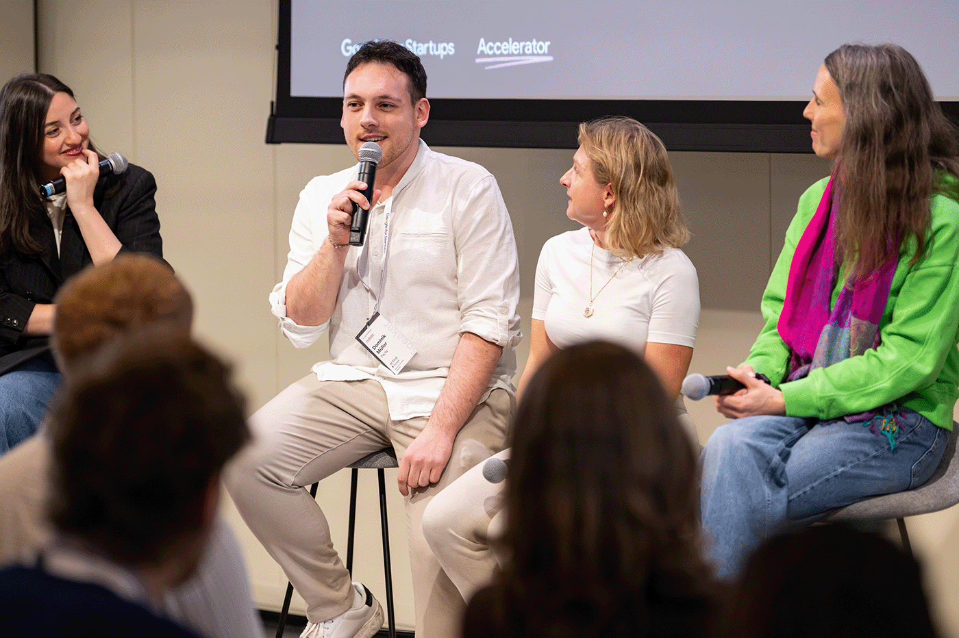 A group of people is engaged in a deep discussion, with microphones in their hands.