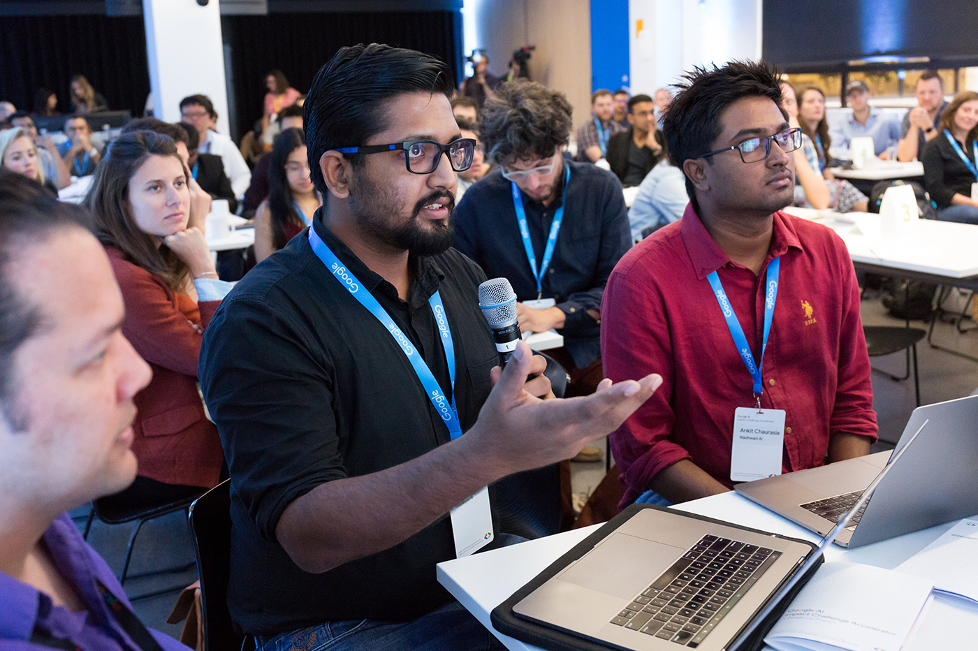 An audience member with a mic questioning the host.