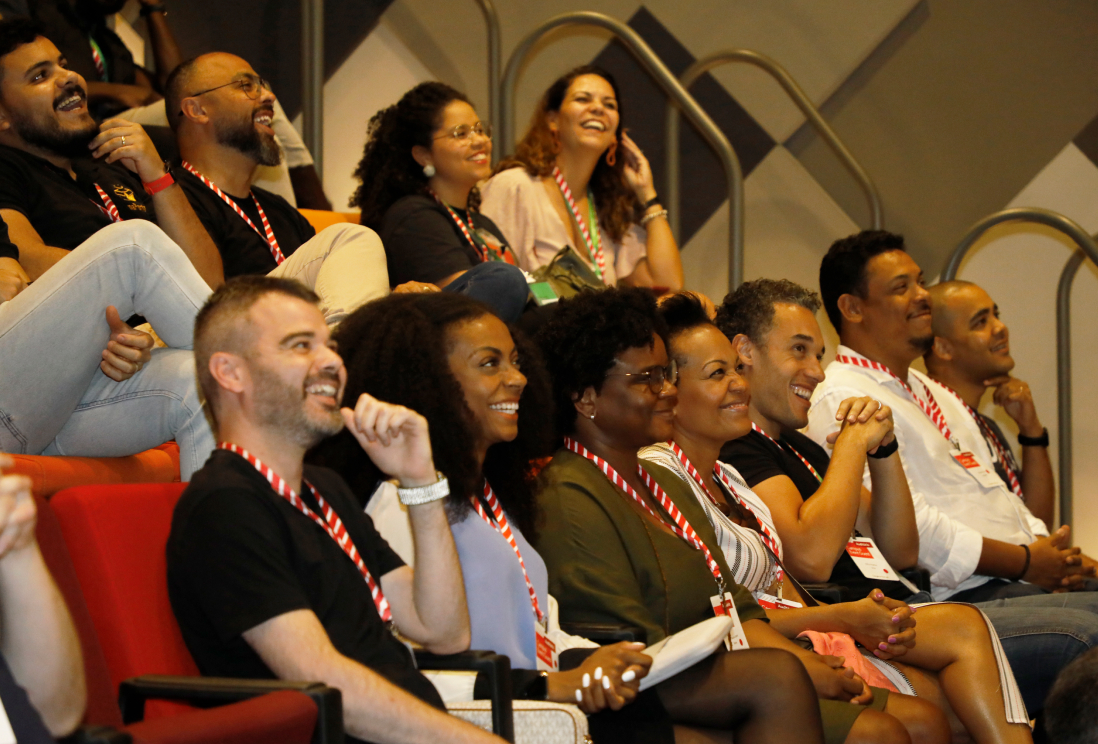 A team sited in the conference room, smiling.