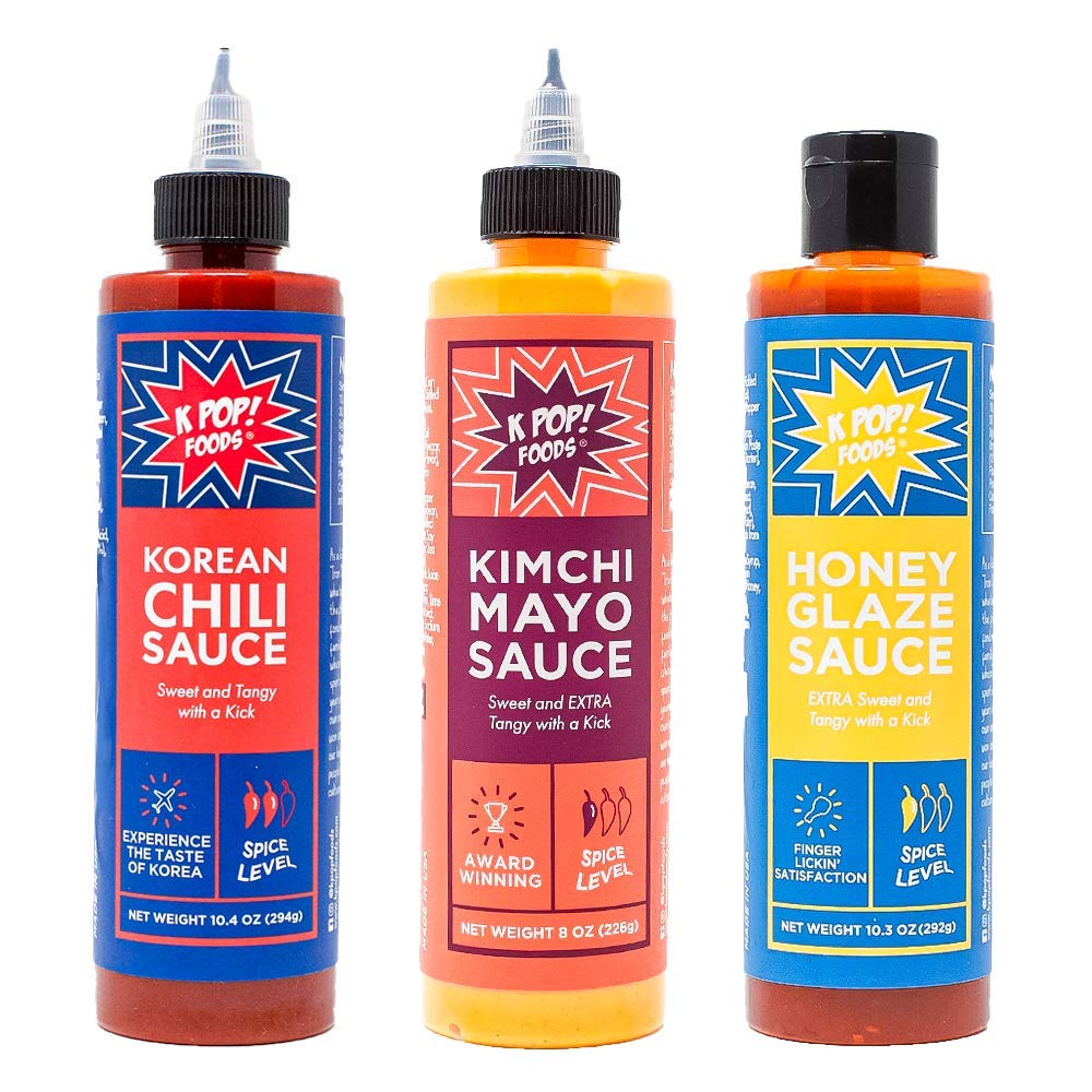 Three bottles of different KPop Foods sauces with brightly-colored labels are arranged side-by-side.