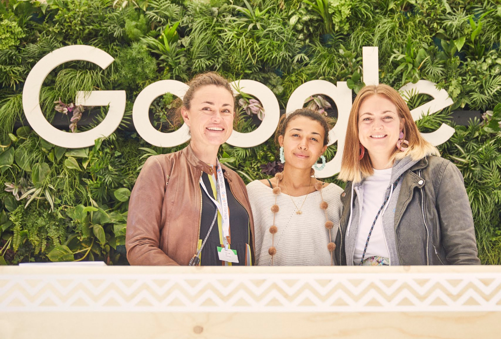 Three women smiling and looking in front.