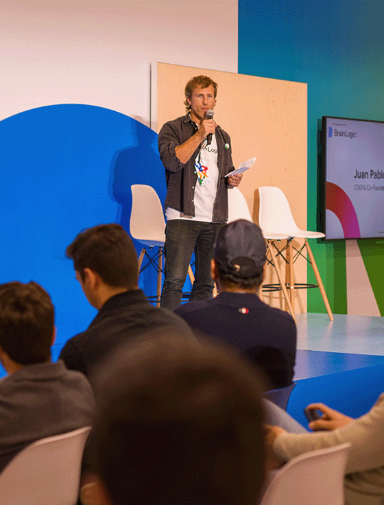 A person is addressing a large event audience with a mic.