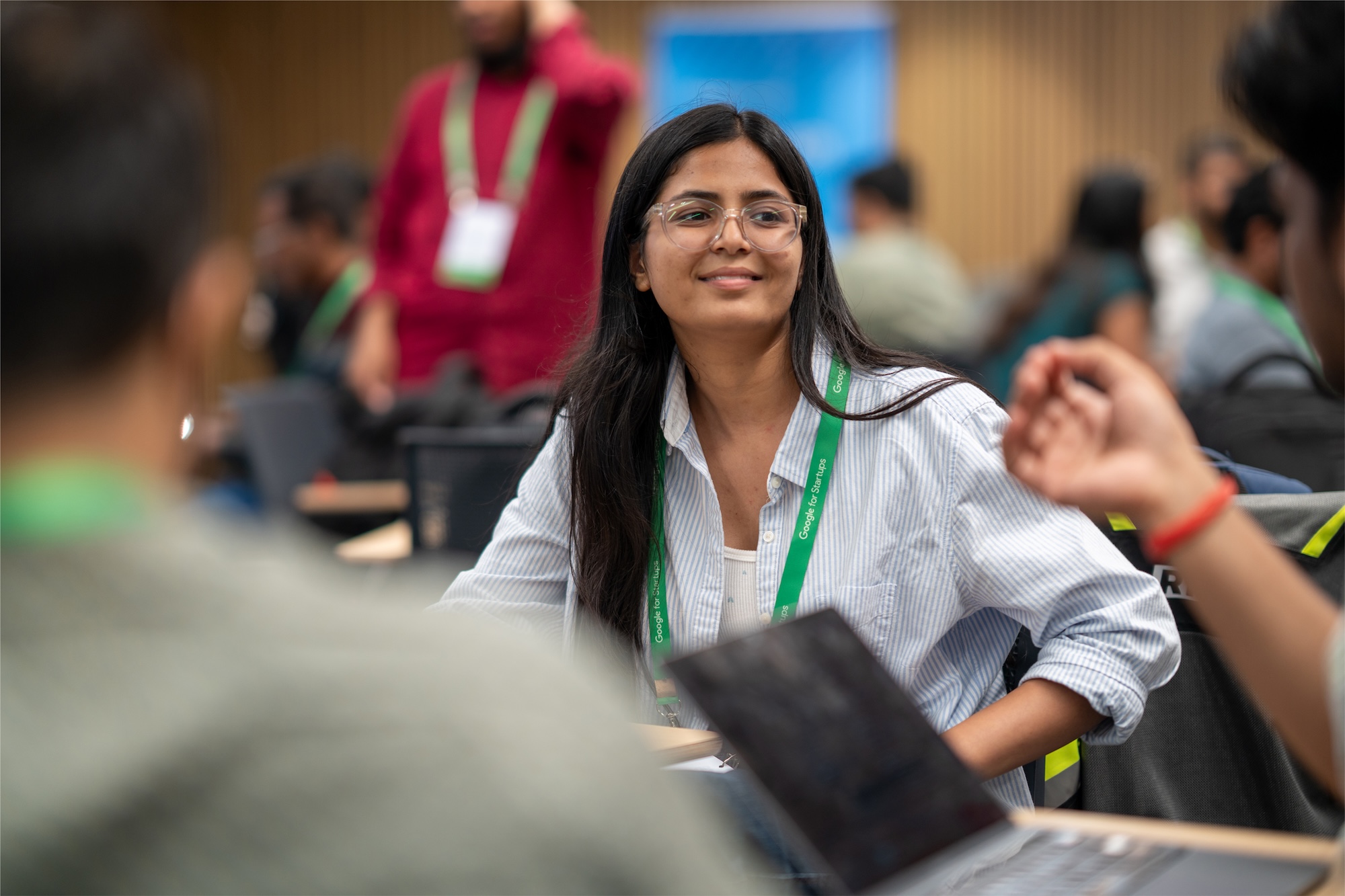 A woman wearing green lanyard looking at someone.