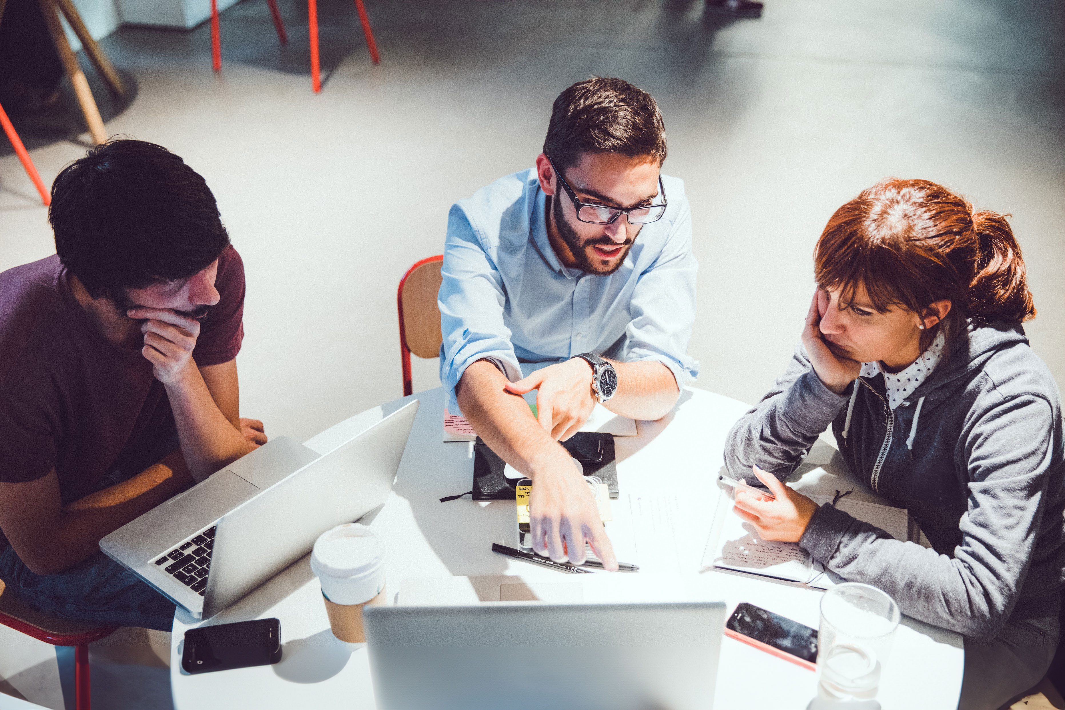 1 人の女性と 2 人の男性がノートパソコンを見ています。