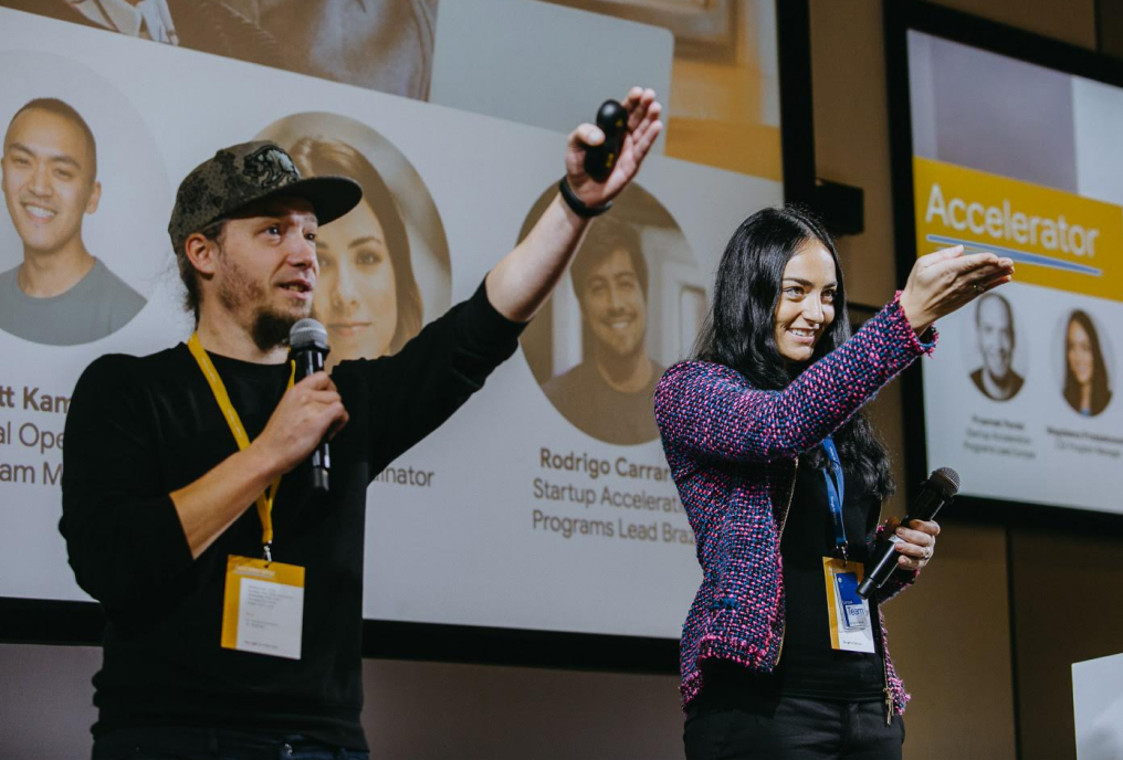 A man and a woman holding mic and speaking to the audience.