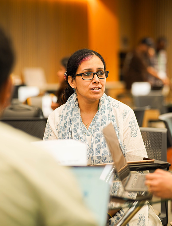 A lady listening intent to a colleague at a social gathering.