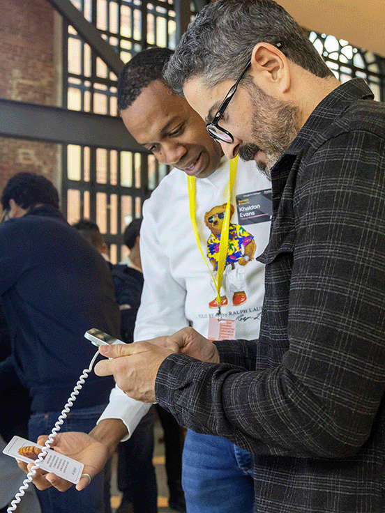 Two people are looking intently at a mobile phone.