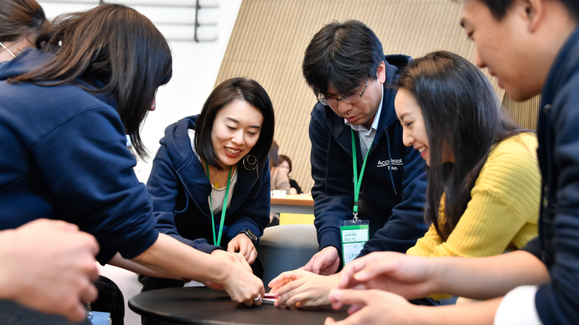 Group of creative friends sitting at wooden table. People having fun while playing