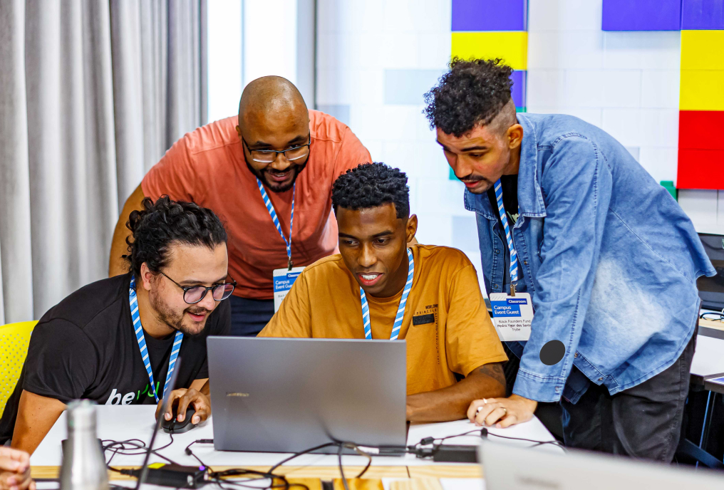 Four persons looking in a laptop