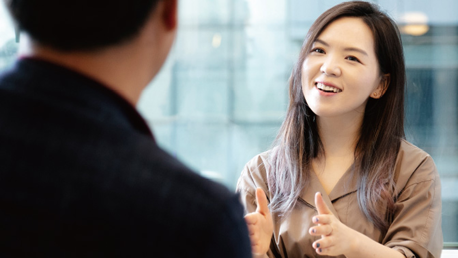 Hanna Kim, da Grip, sorrindo e conversando com um homem