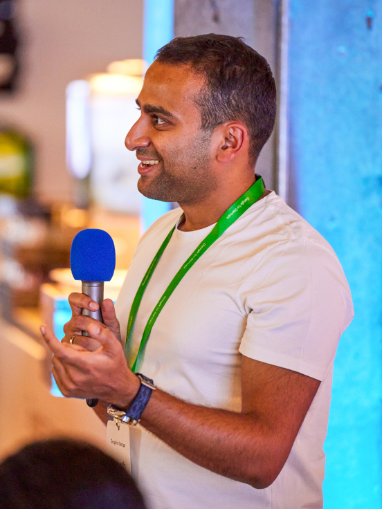 A man holding a mic in hand and smiling.