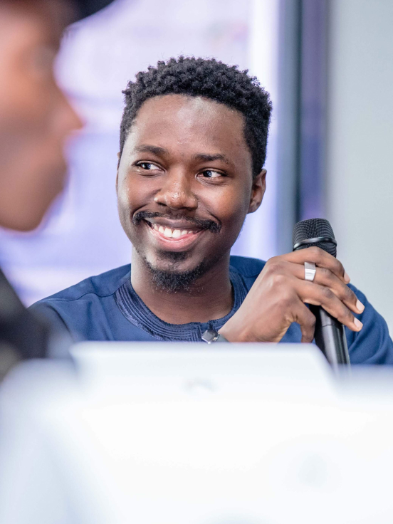 A man holding a mic and smiling.