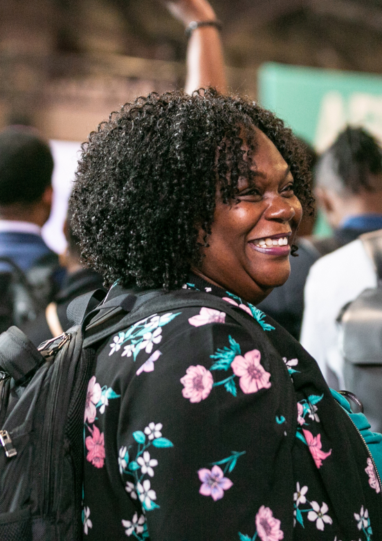 Woman chatting with a lady, smiling.