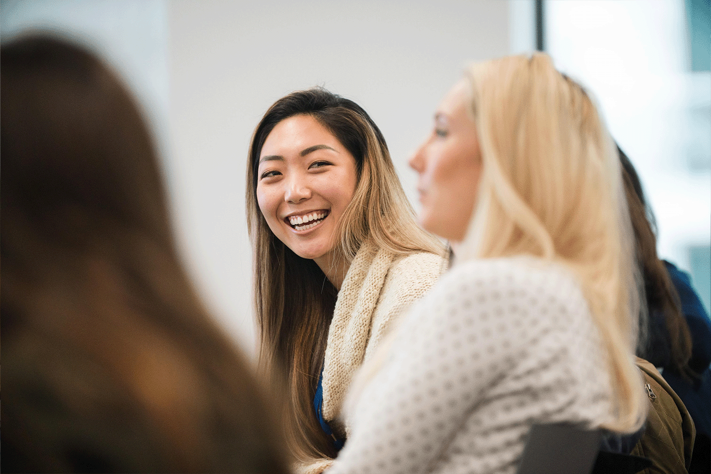 A lady in the group is looking at another lady with a smile.