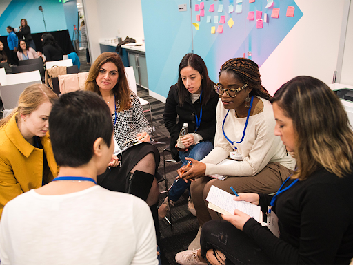 A group of women, sitting in a circle and discussing.