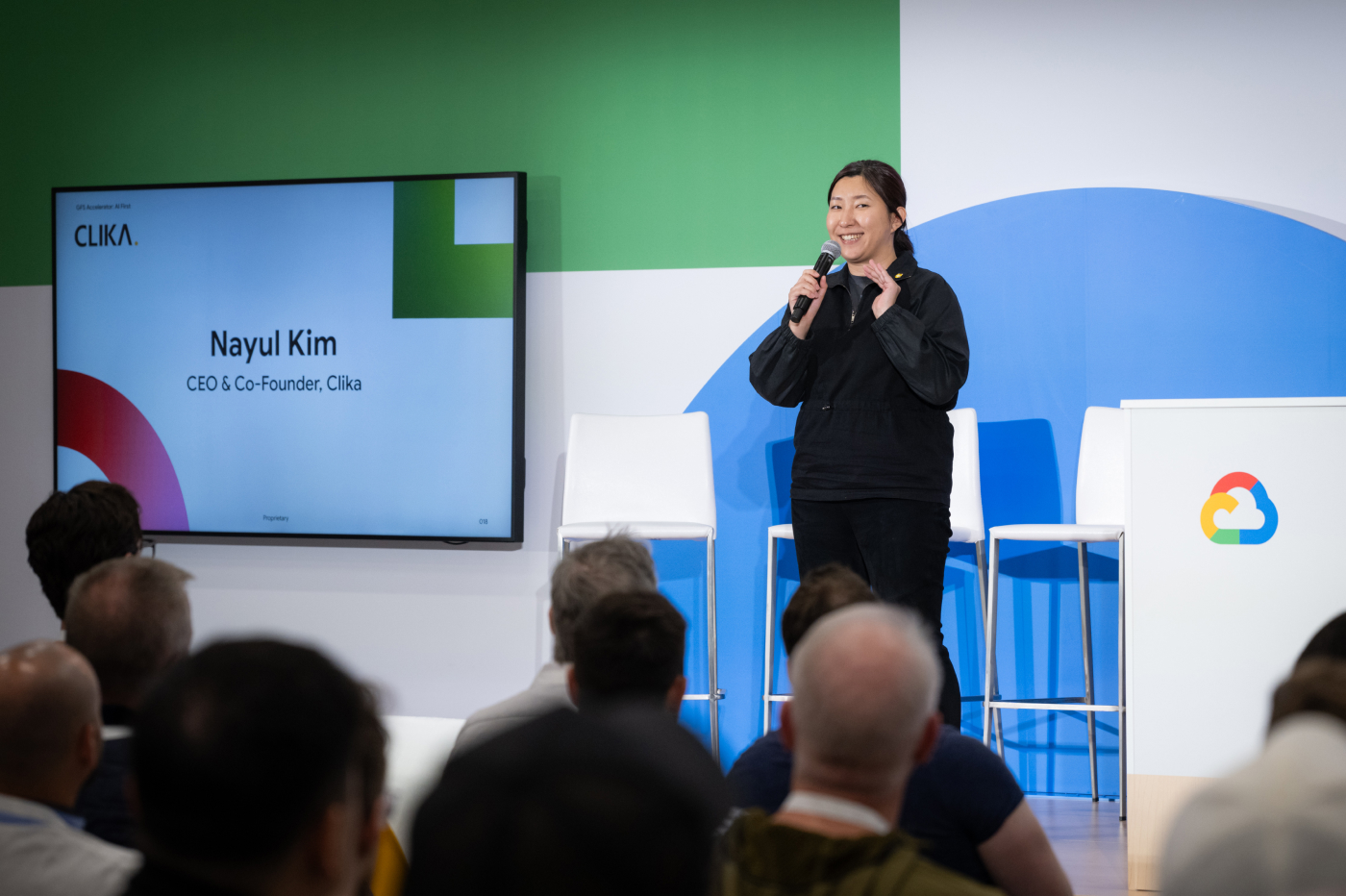 A woman is delivering a presentation with a smile.