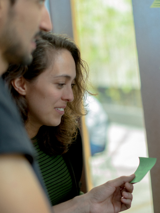 A lady and Men looking toward note page.