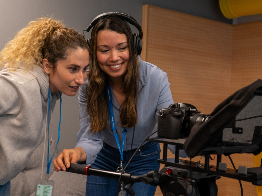 a woman showing another woman pictures on DSLR